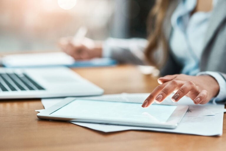 businesswoman using tablet while another writes 2026 01 09 10 30 47 utc scaled